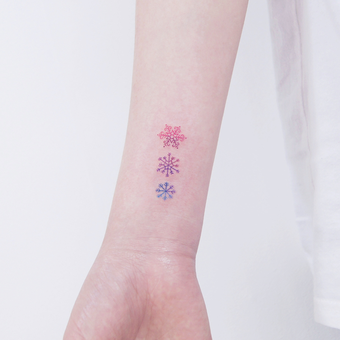 Tiny Colored Snowflakes on Wrist by tattooist_dal